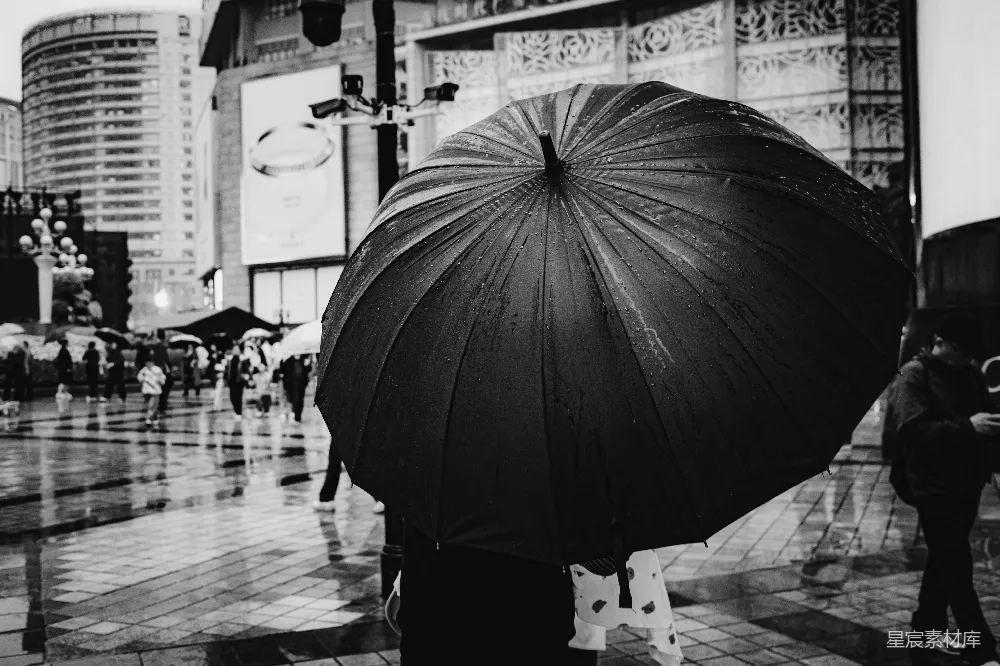 高清摄影 一张黑白照片中有人拿着雨伞。