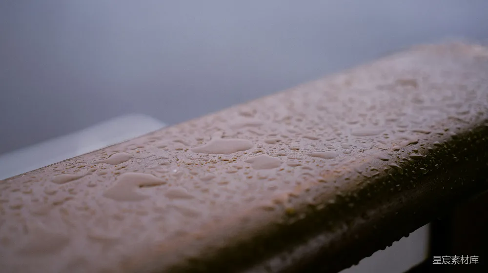 高清摄影 雨滴覆盖着一个雨天的木栏杆。