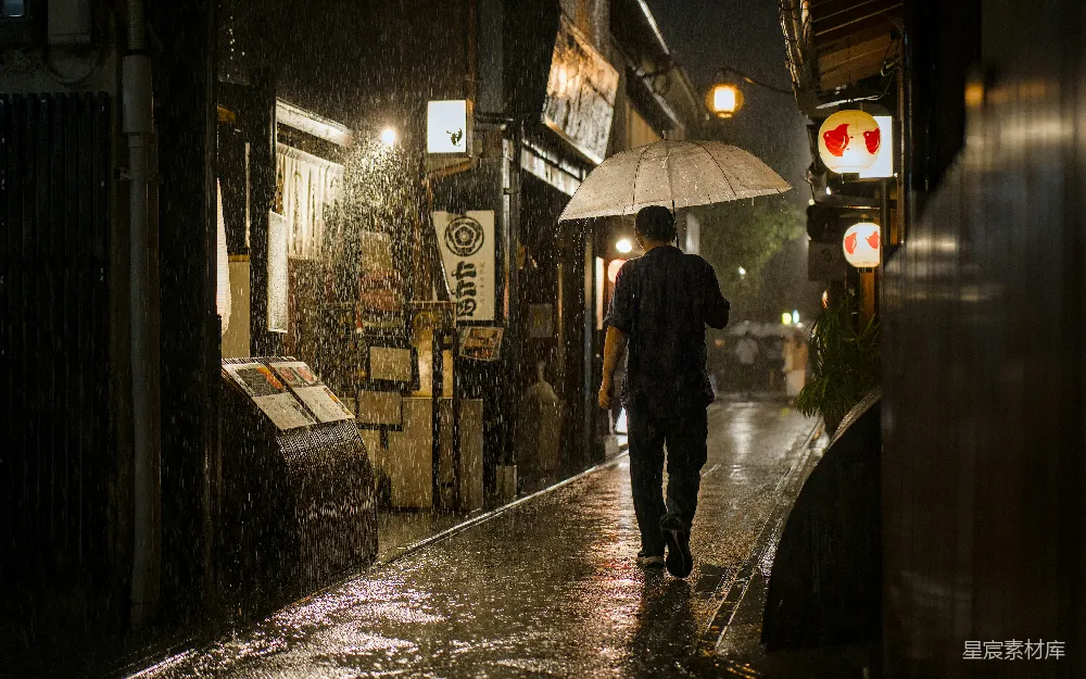 高清摄影 夜幕下一个人在雨中步行，手握伞。