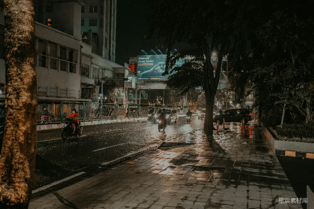 高清摄影 一群人在一条雨水浸湿的街道上骑摩托车。