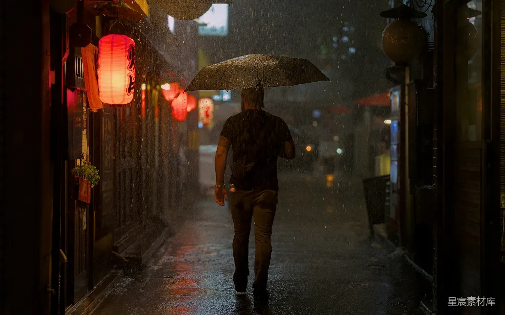 高清摄影 夜晚行人打着伞走在雨中的城市街道上