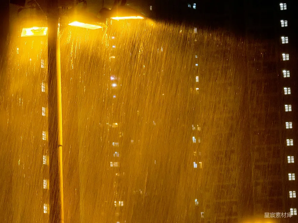 高清摄影 夜幕下，街灯在大雨中照亮一座黑暗的建筑物。