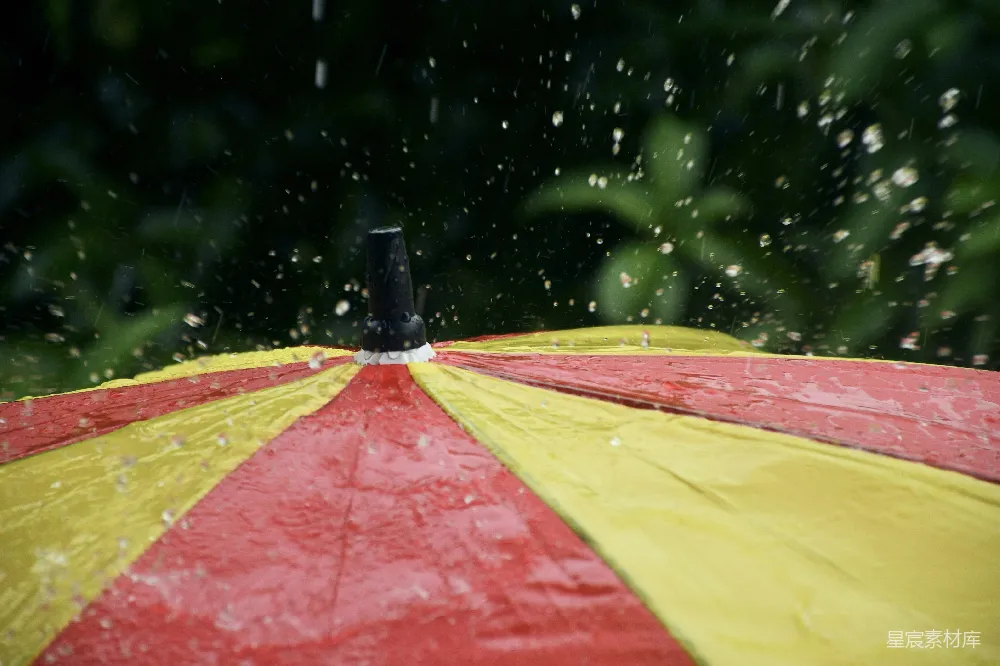 高清摄影 一把红黄相间的雨伞在雨中。