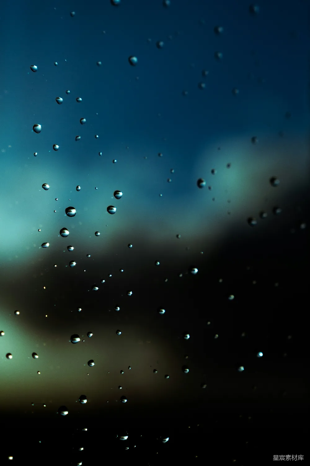 高清摄影 玻璃上滴落的雨珠，带有暗淡模糊的背景。