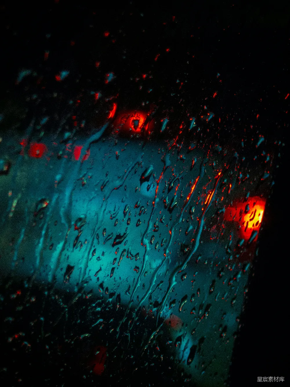 高清摄影 雨滴落在玻璃上，闪烁着红蓝灯光的景象。