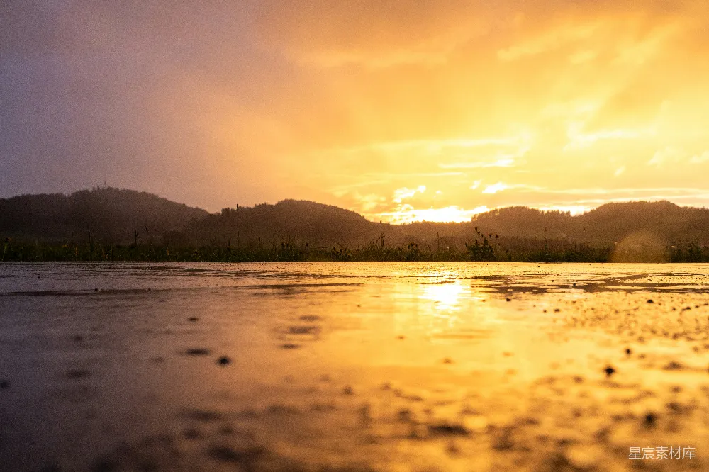 高清摄影 日落在一场暴风雨后反射在水面上。