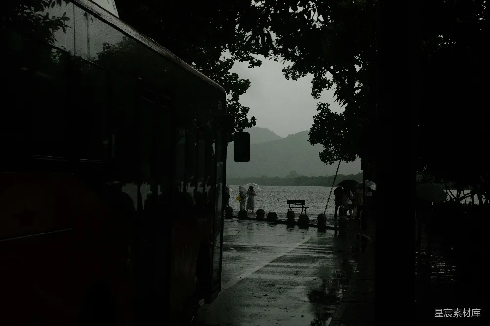 高清摄影 公交车在雨天停靠在一湖边。