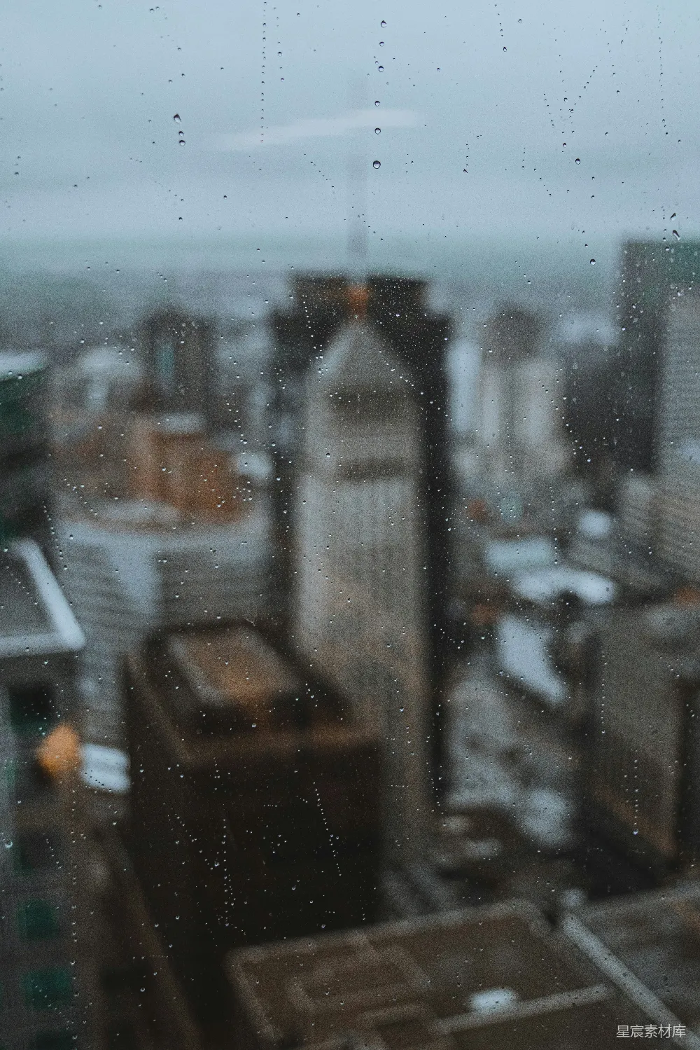 高清摄影 窗前滴落的雨滴，城市在背后。