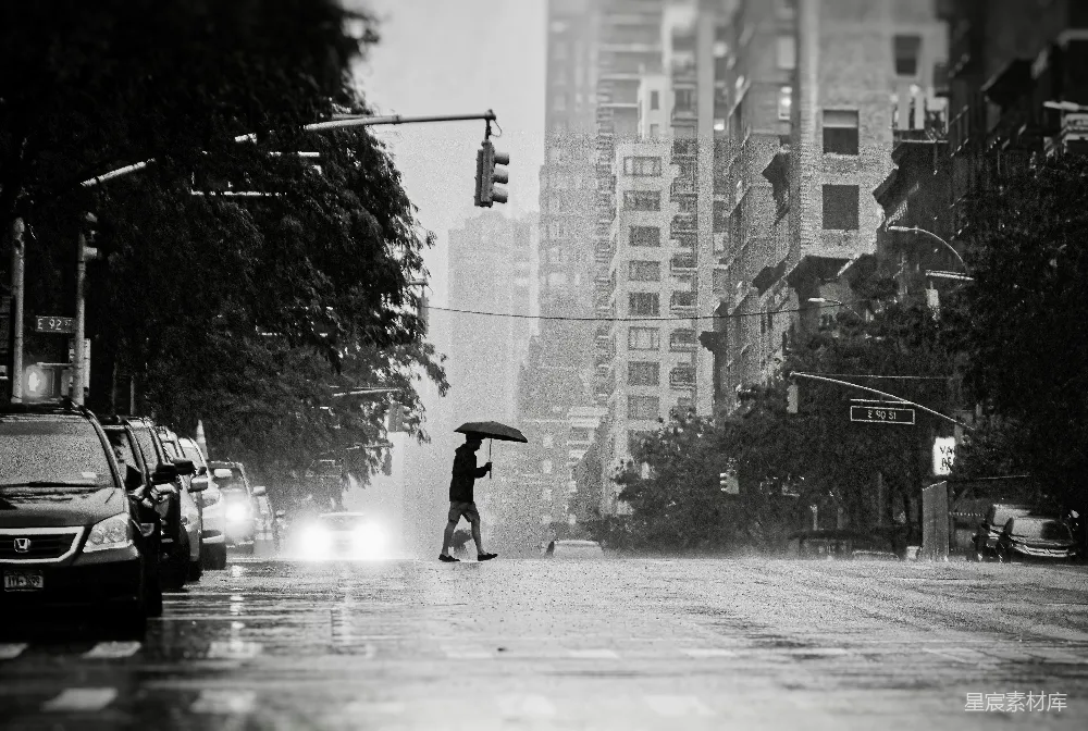 高清摄影 手持雨伞的人正在过马路
