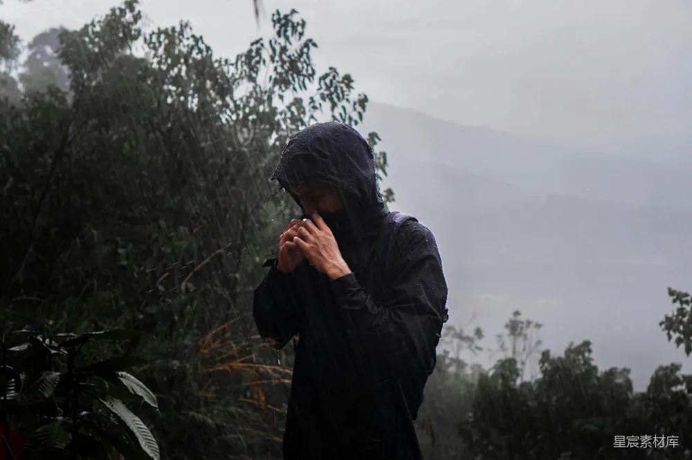 高清摄影 穿着雨衣的人站在雨中