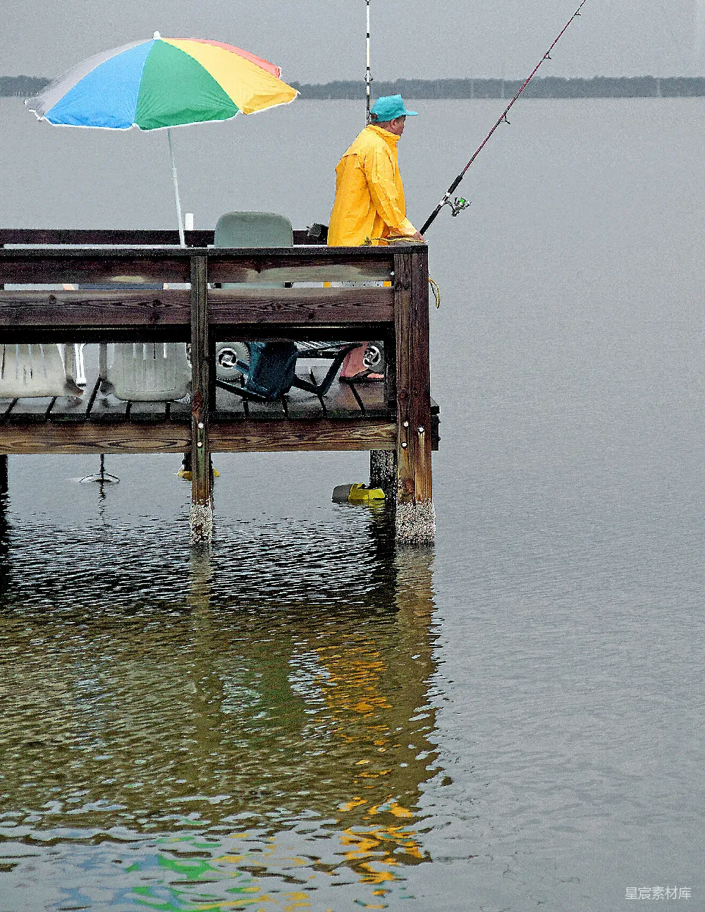 高清摄影 渔人正在雨中从码头钓鱼。