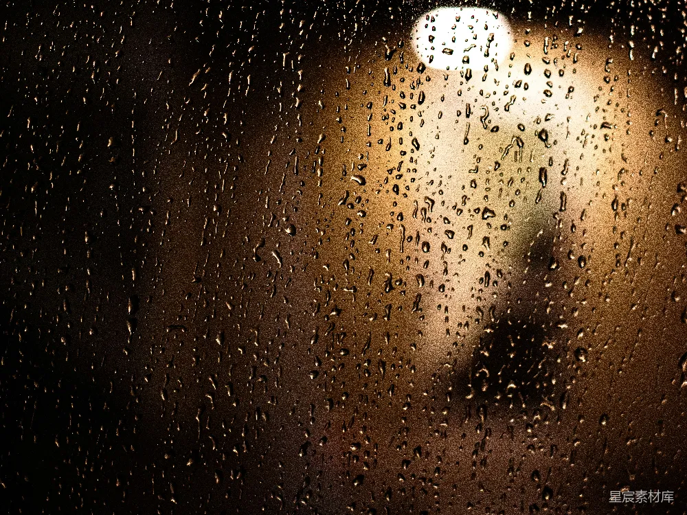 高清摄影 玻璃上的雨滴带着模糊的光线。