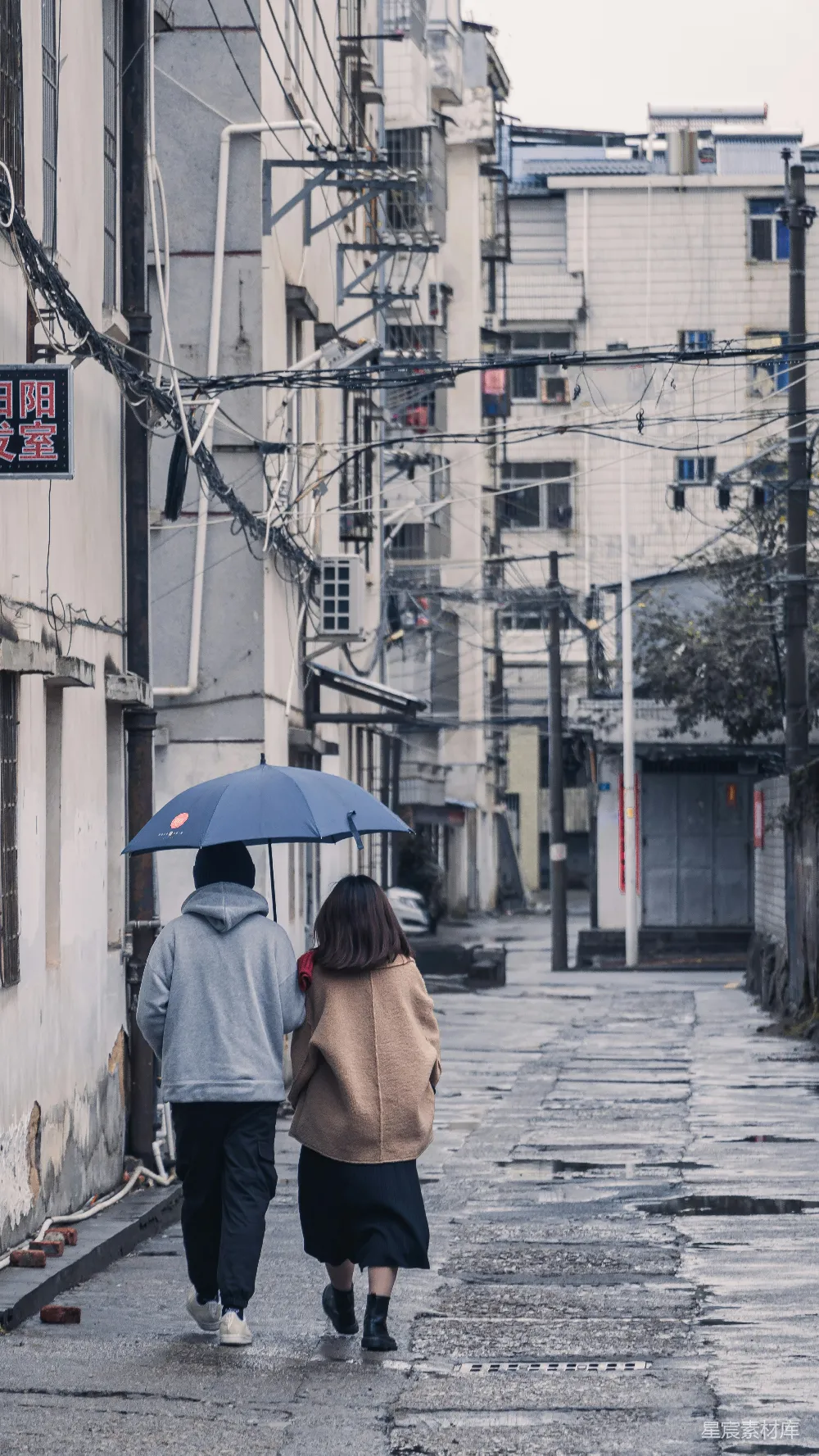 高清摄影 几个拿着伞的人正在街上行走。