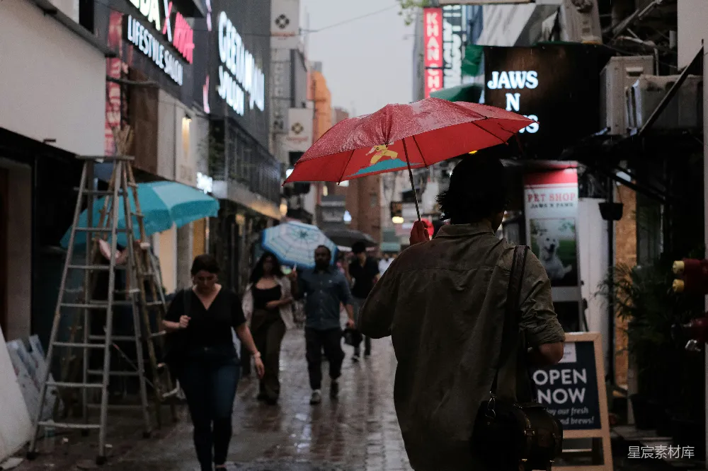 高清摄影 一个女人走在街上拿着雨伞