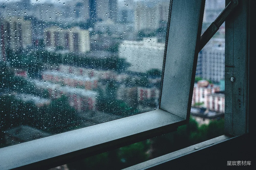 高清摄影 窗前滴落的雨珠俯瞰着一片模糊的城市景观。