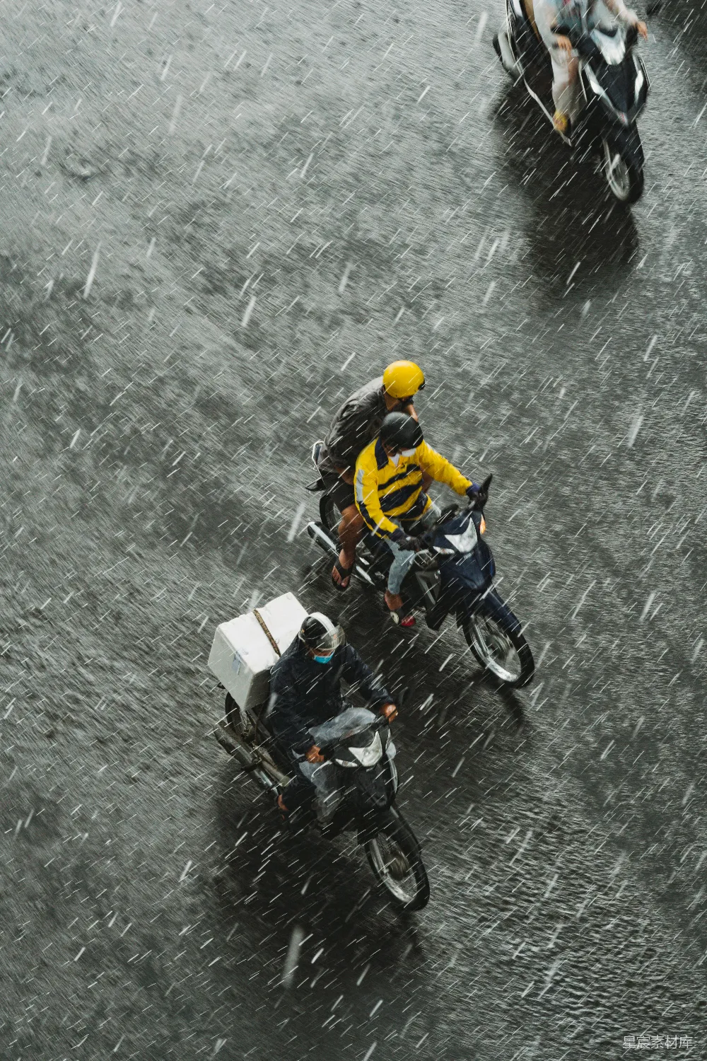 高清摄影 一群人在雨中骑摩托车。