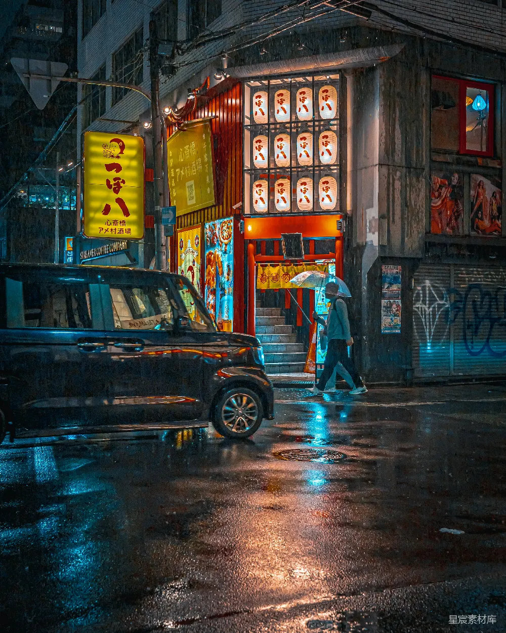 图片展示了一个雨夜中的城市街景，街边的店铺被彩色霓虹灯照亮，营造出一种温暖而迷人的氛围。街道上停着一辆黑色的车，一名行人打着伞走过，背景中的建筑上挂着各种色彩鲜艳的广告牌，整个场景充满了都市的活力与神秘感。