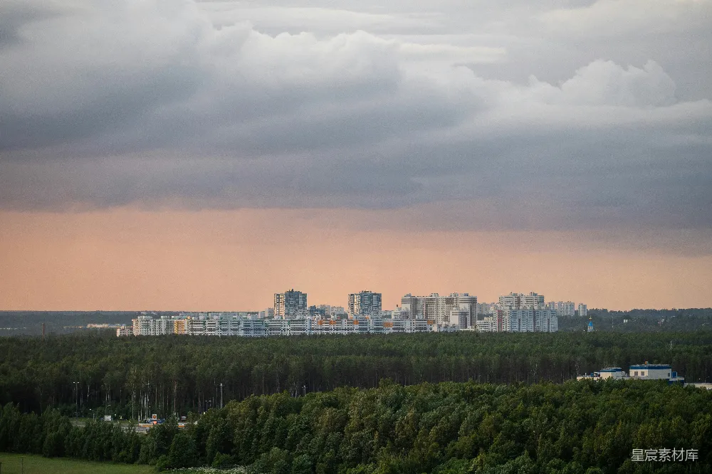 高清摄影 夕阳下的绿树与城市建筑