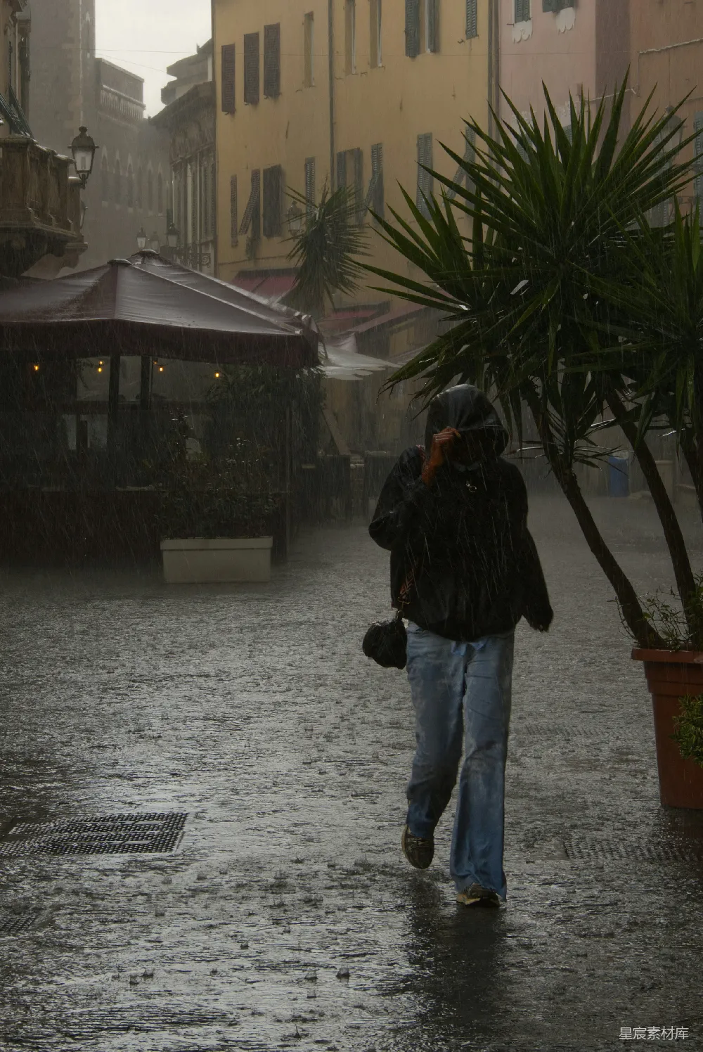 高清摄影 行人穿过一个雨中的欧洲街道。