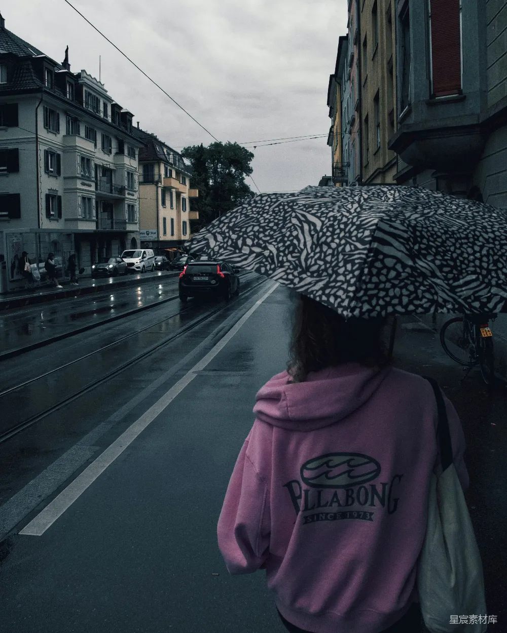 高清摄影 女人在雨中撑伞走在城市街道上。