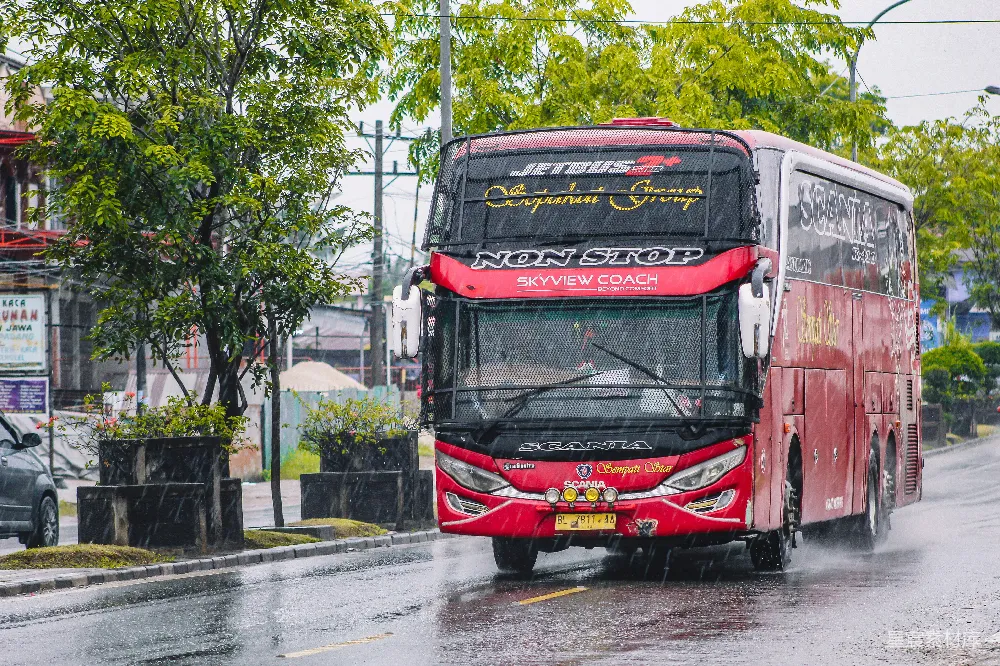高清摄影 白天红黑双色公交车在路上行驶