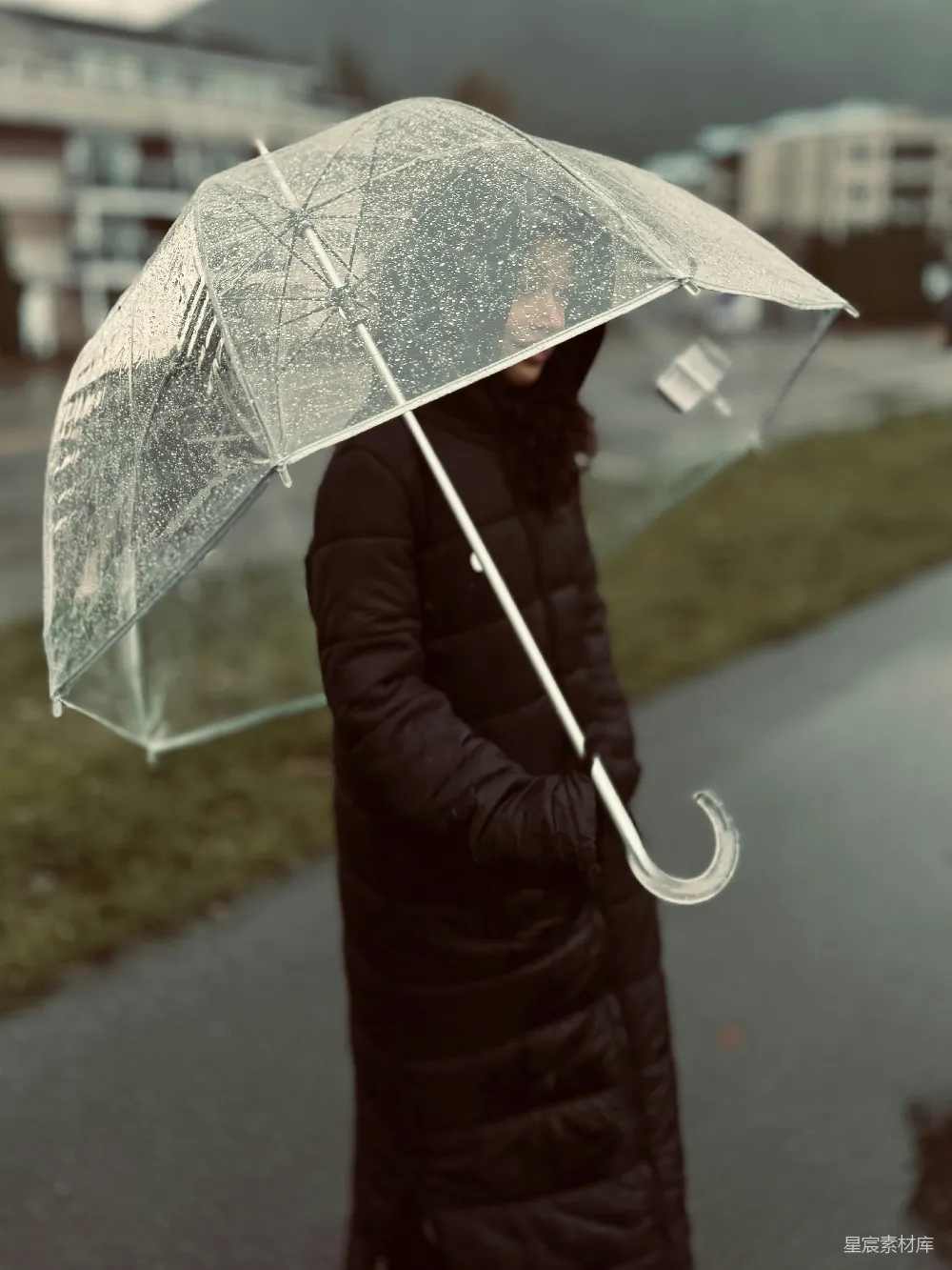 高清摄影 一个穿着黑色外套的女人撑着一把透明的雨伞