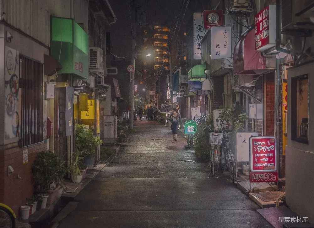 高清摄影 夜晚一条狭窄的城市街道上有人在行走。