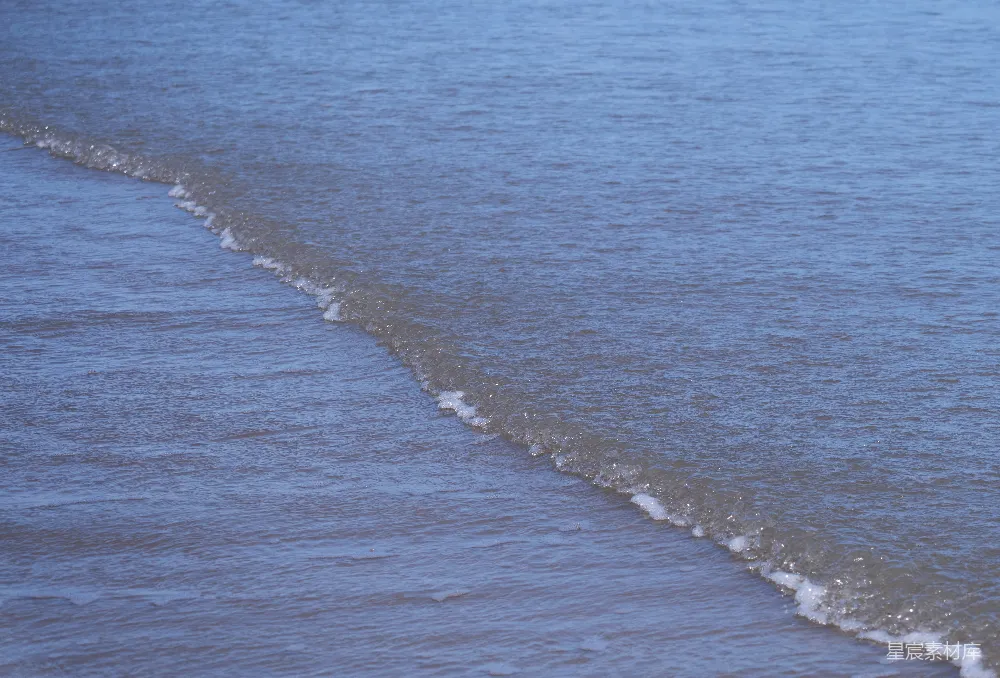 高清摄影 海边一个男子骑在海浪上的冲浪板上