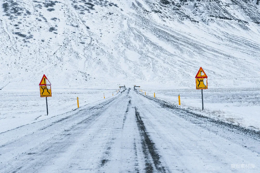 高清摄影 覆盖着白雪的道路并带有警告标志