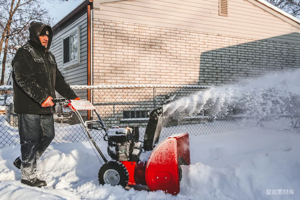 高清摄影 红白相间的雪地车在覆盖着白雪的地面上行驶。