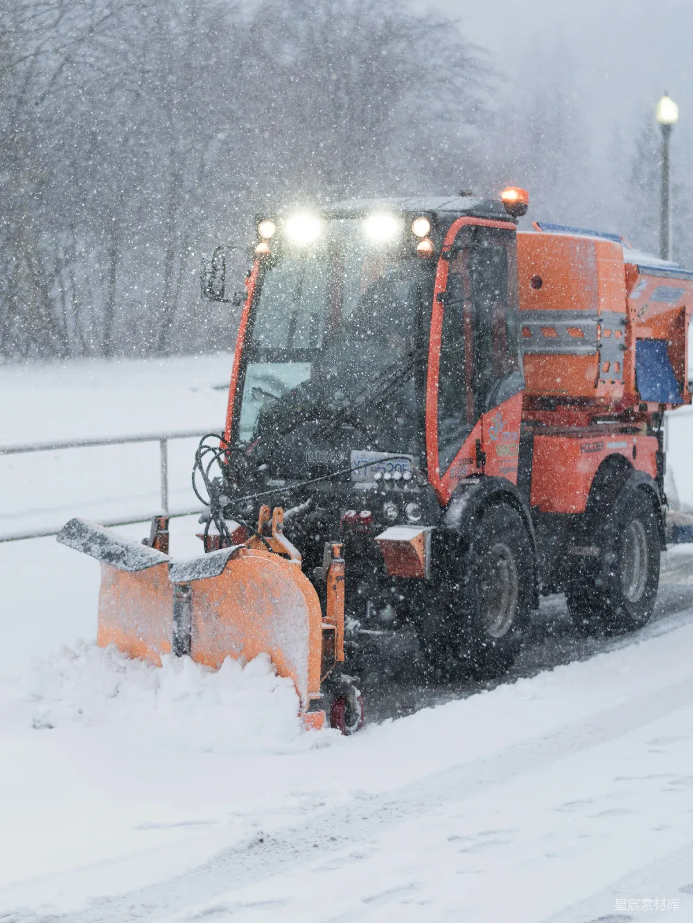 高清摄影 一辆雪犁在覆盖着积雪的道路上行驶。