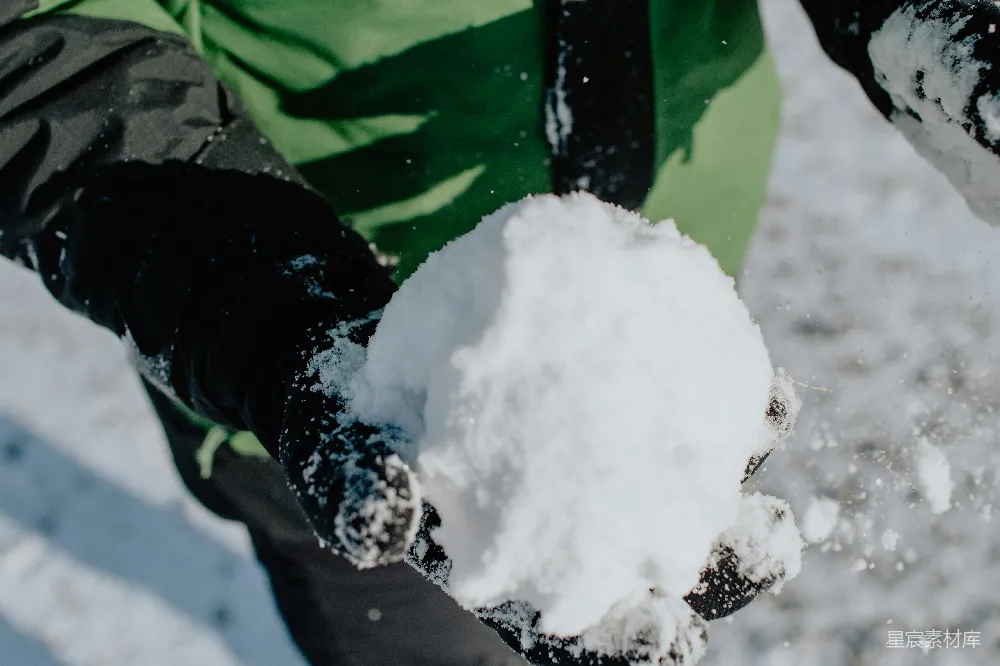 高清摄影 穿着绿黑夹克的人举着手雪