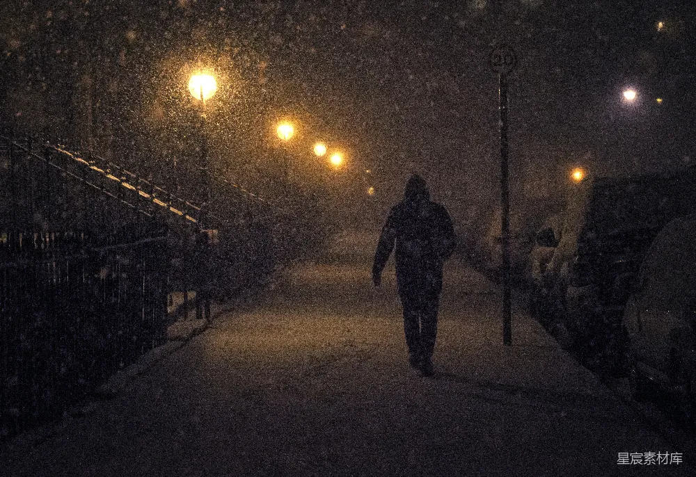 高清摄影 夜晚行人戴着帽子在雪中行走