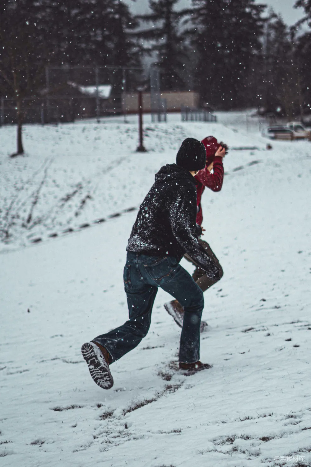 高清摄影 穿着黑色斗篷夹克的男人在雪地里行走