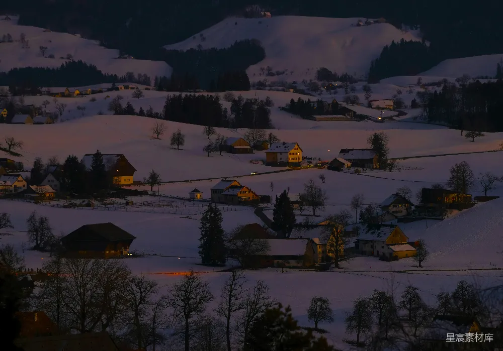 高清摄影 夜晚雪景中有一座小屋和几棵树