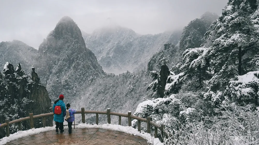 高清摄影 几个人在山顶上站着，山顶被雪覆盖着。