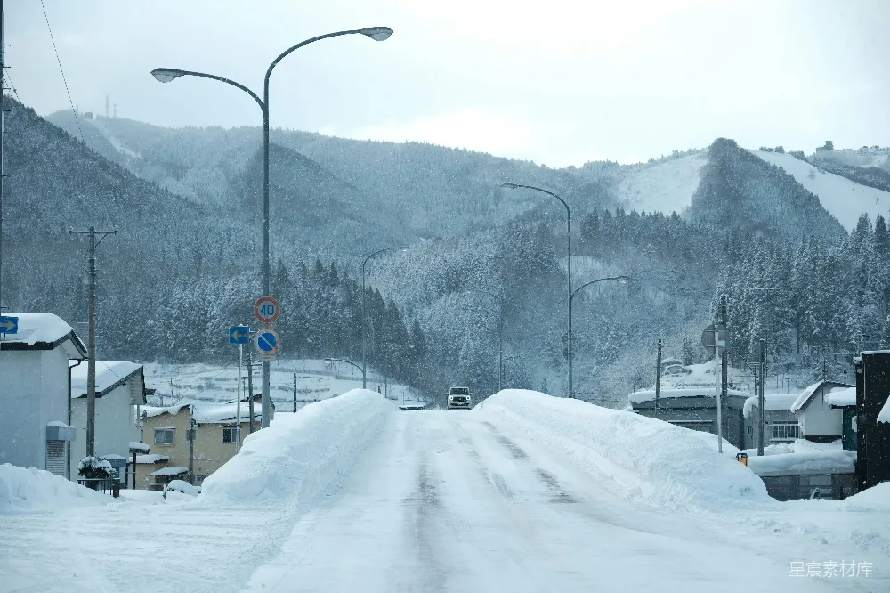 高清摄影 覆盖着白雪的道路，山峰在背景中。