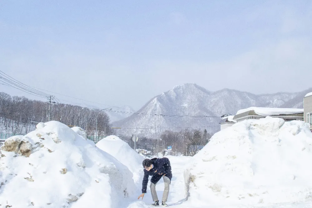 高清摄影 跪在雪地里旁边的一个雪堆上的男人