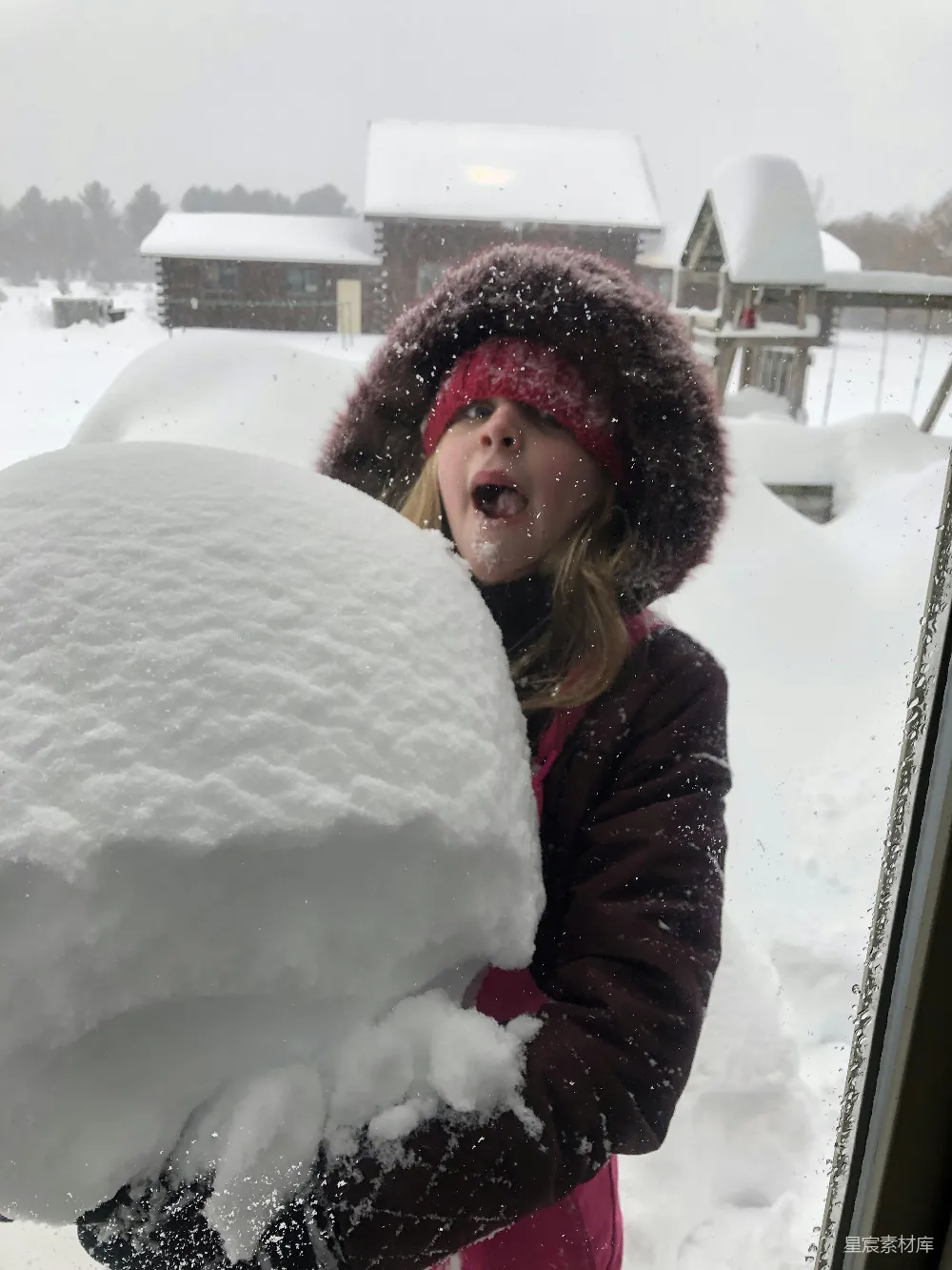 高清摄影 一个女孩站在覆盖着白雪的窗前。
