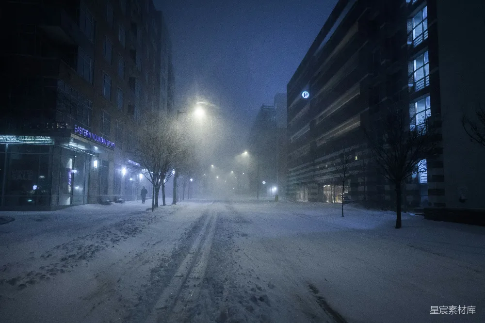 高清摄影 夜晚建筑物之间覆盖着白雪的道路
