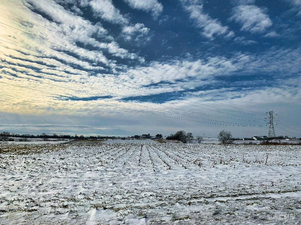 高清摄影 一片覆盖着白雪的田野，远处有电线杆。