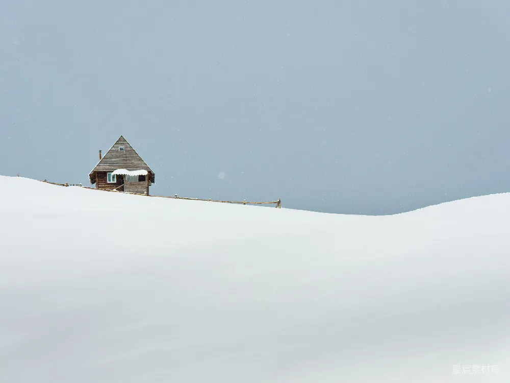 高清摄影 一座小屋坐落在白雪覆盖的山坡上。
