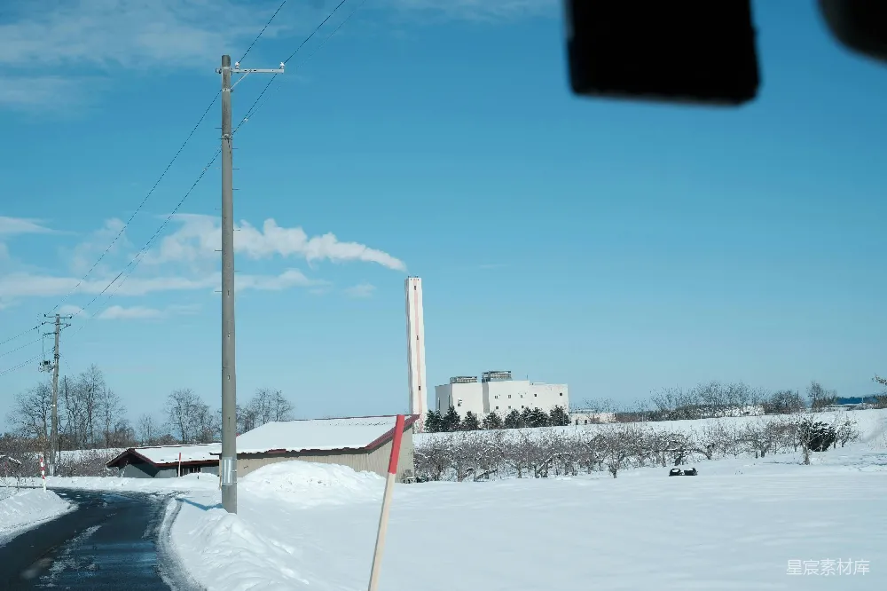 高清摄影 背景中有座建筑的雪地小路