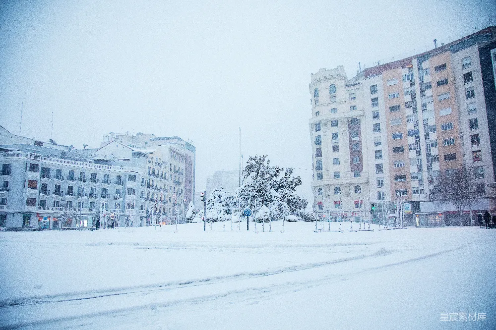 高清摄影 白天白雪覆盖着近处的白色混凝土建筑附近的田野。
