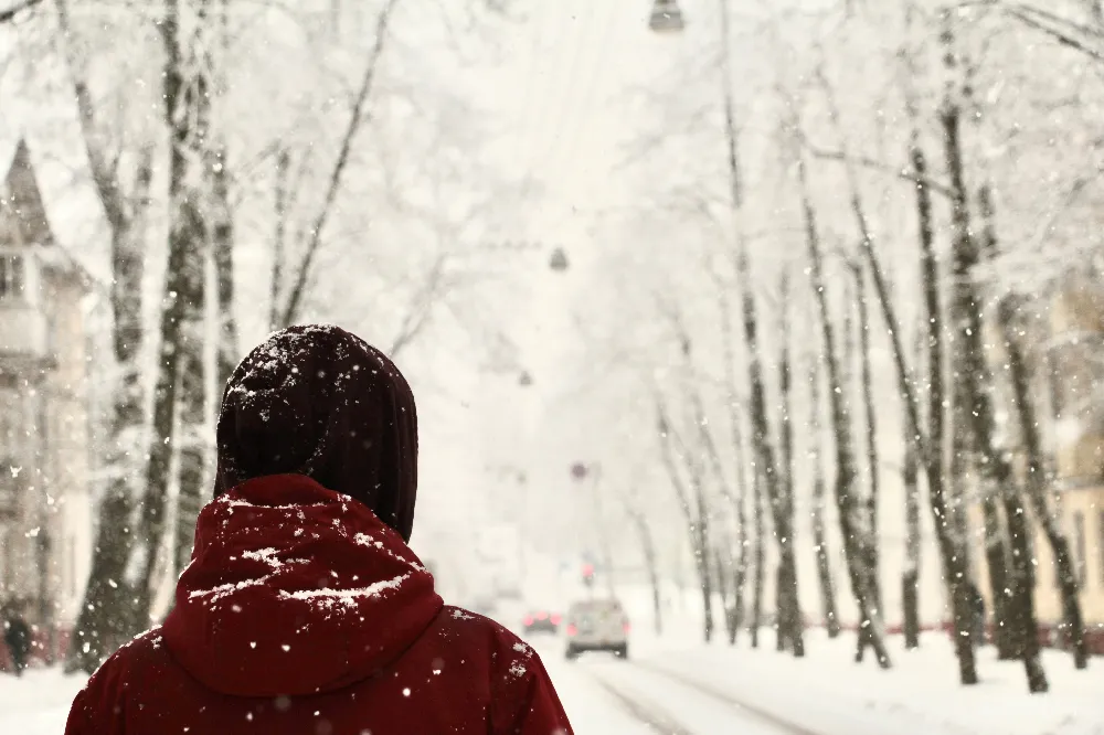 高清摄影 一个穿红色夹克的女人走在覆有白雪的小街上