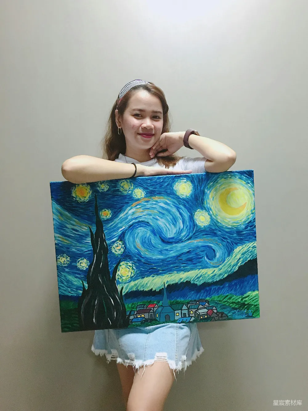 高清摄影 微笑的妇女站立着并拿着梵高创作的《星夜》油画。