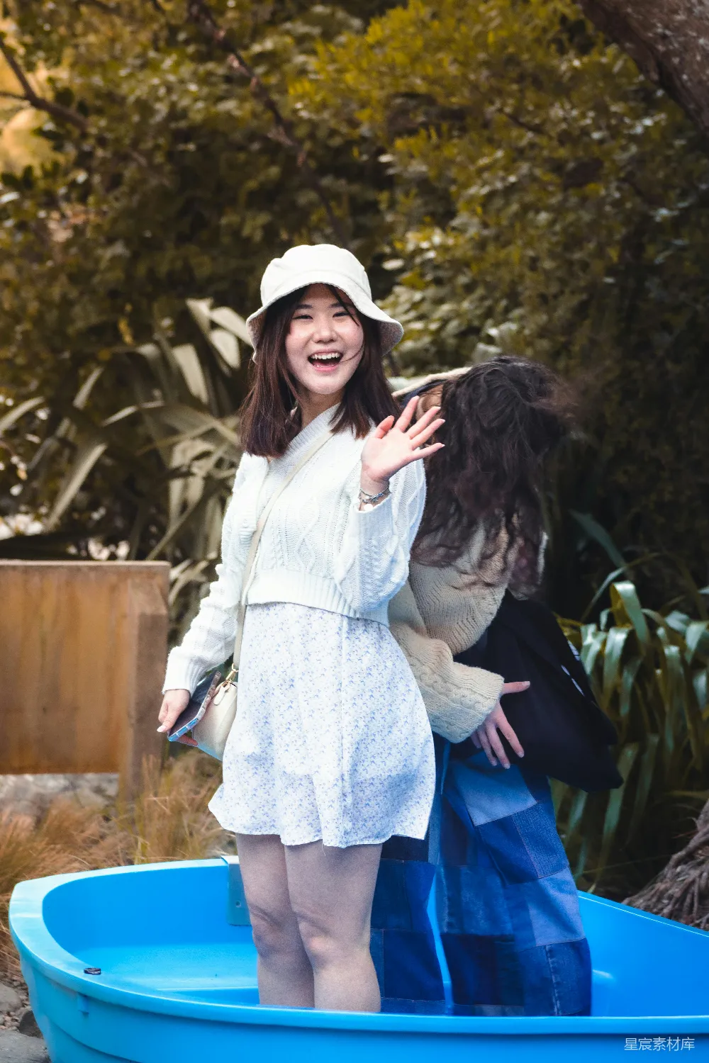 高清摄影 一个穿着白色连衣裙和帽子的女人站在蓝色的泳池中。