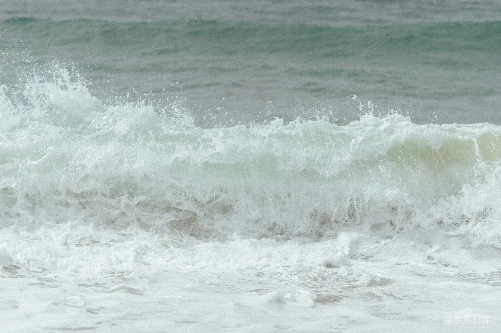 高清摄影 海边一个男子骑在波浪上的冲浪板上