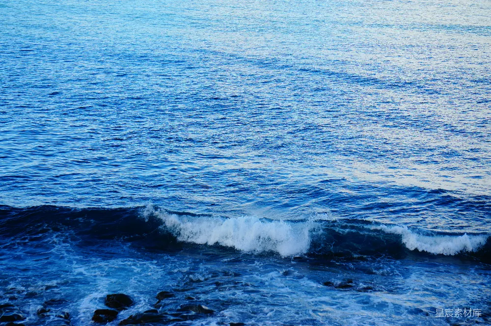 高清摄影 蓝色的大海波浪上泛着白色的泡沫，靠近岸边。