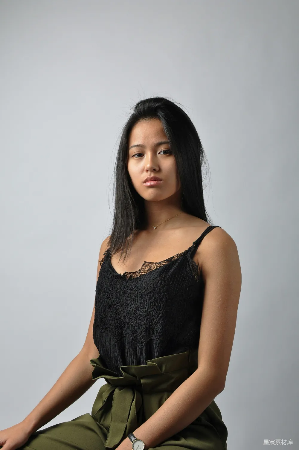 高清摄影 一个穿着黑色上衣和绿色裤子的女人